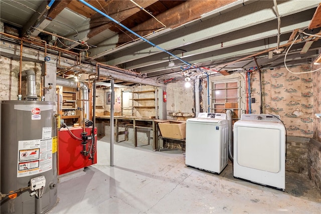 basement with washing machine and dryer, sink, and gas water heater