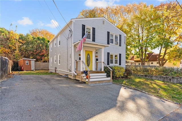 view of front facade featuring a front lawn and a storage unit