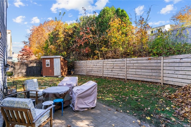 view of patio featuring a storage unit and a grill