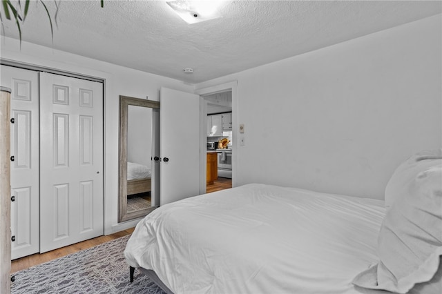 bedroom featuring a closet, a textured ceiling, and hardwood / wood-style flooring