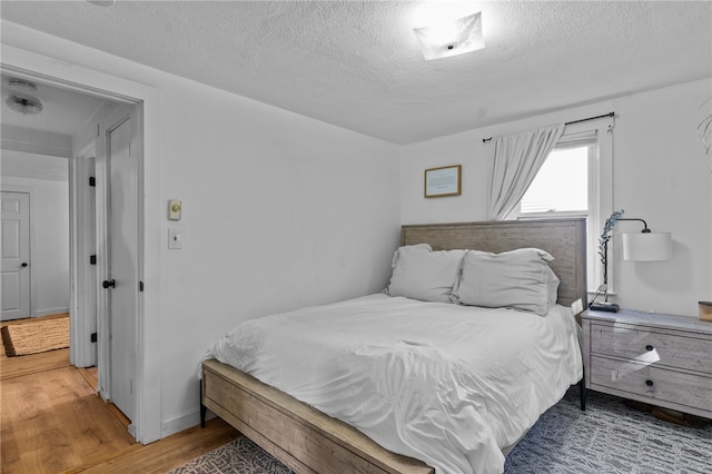 bedroom with hardwood / wood-style floors and a textured ceiling