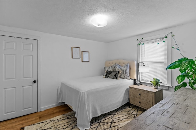 bedroom featuring a textured ceiling and light wood-type flooring