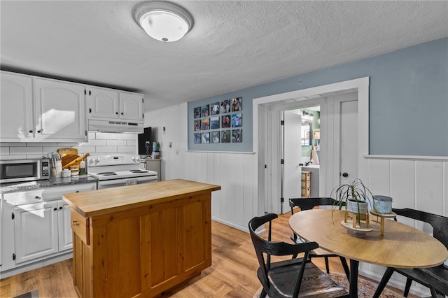 kitchen with white range with electric cooktop, light hardwood / wood-style flooring, a textured ceiling, tasteful backsplash, and white cabinetry