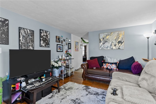 living room with a textured ceiling and dark hardwood / wood-style flooring