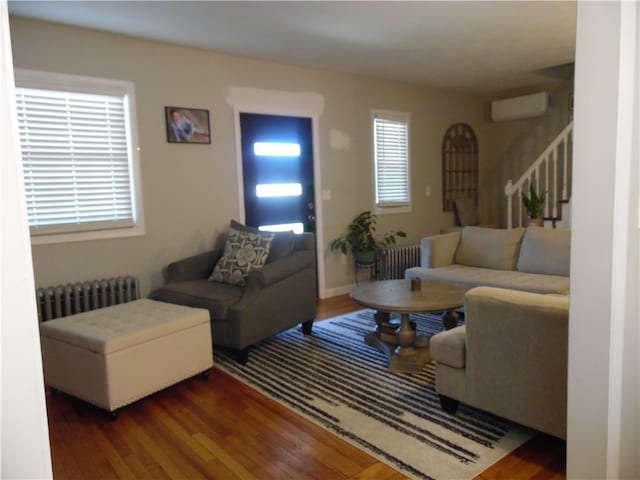 living room featuring a wall unit AC, radiator, and dark hardwood / wood-style floors