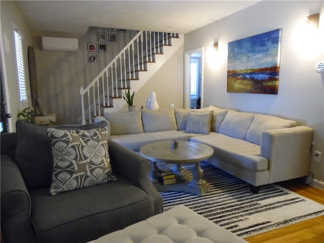 living room featuring wood-type flooring and a wall mounted air conditioner