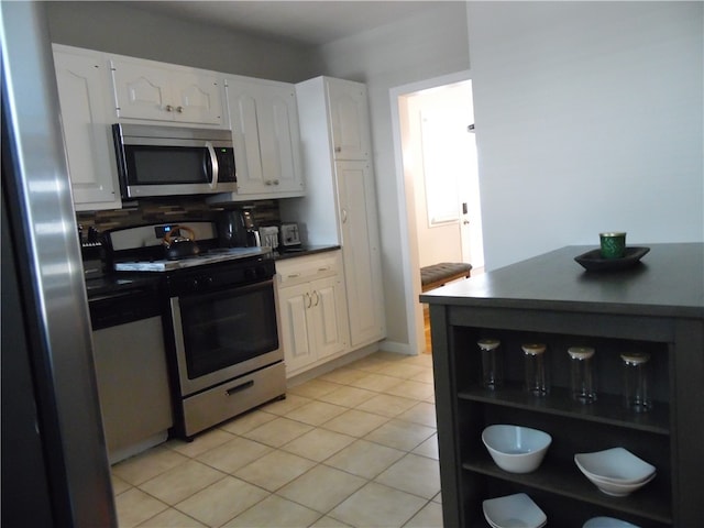 kitchen featuring white cabinets, stainless steel appliances, and light tile patterned floors