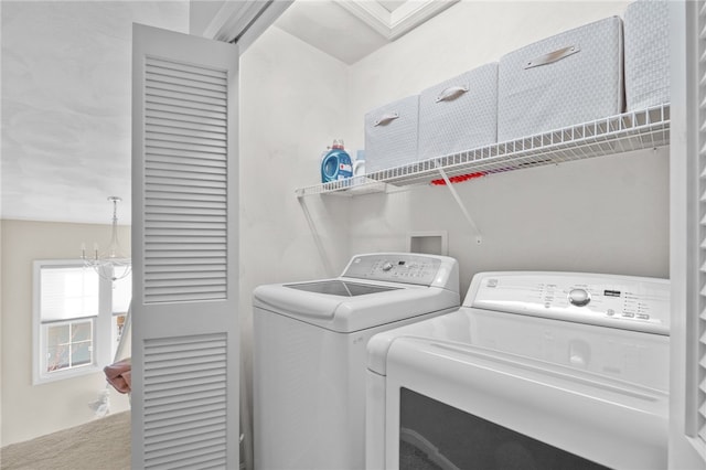 clothes washing area featuring an inviting chandelier, carpet floors, and washing machine and clothes dryer