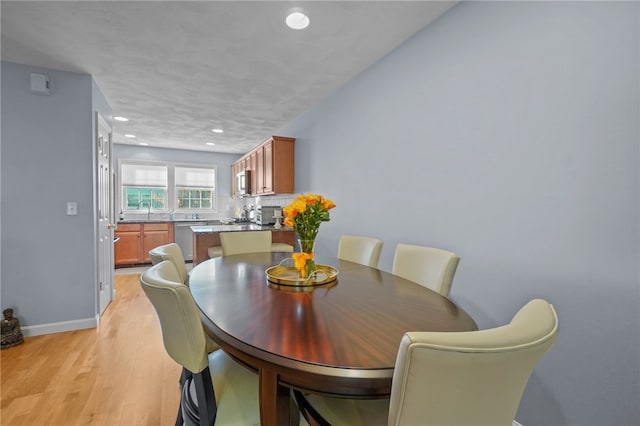 dining space featuring sink and light wood-type flooring