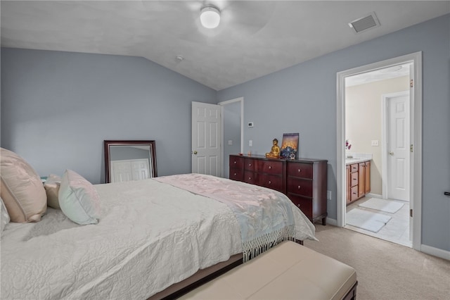 bedroom featuring light carpet, ceiling fan, ensuite bathroom, and lofted ceiling