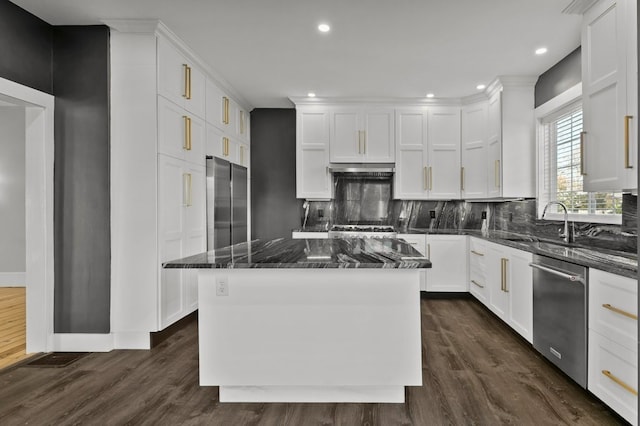 kitchen featuring dark hardwood / wood-style flooring, tasteful backsplash, a kitchen island, appliances with stainless steel finishes, and dark stone countertops