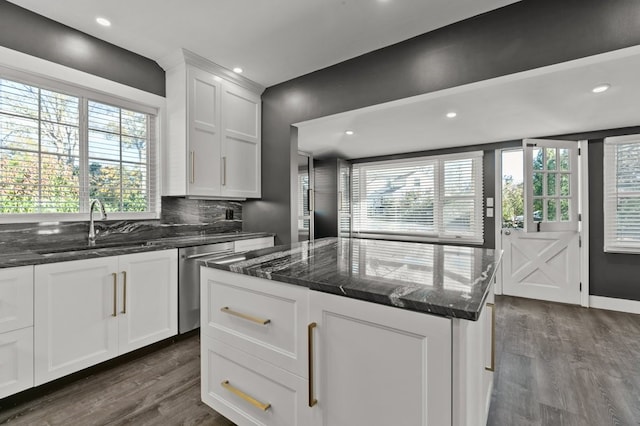 kitchen featuring dishwasher, a kitchen island, white cabinets, and plenty of natural light