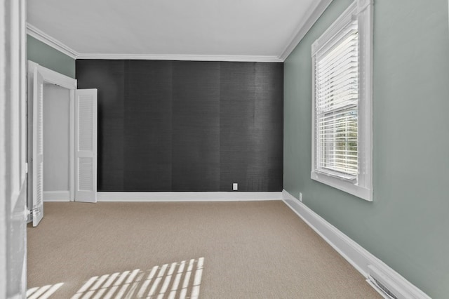 empty room with light colored carpet and crown molding