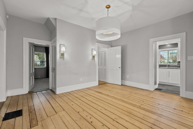 unfurnished bedroom featuring multiple windows and light hardwood / wood-style flooring