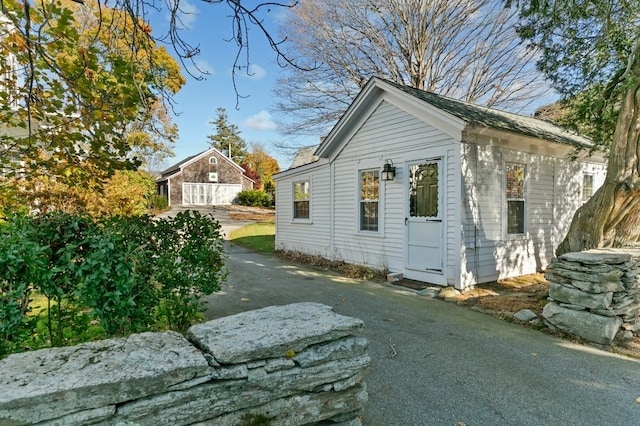 view of side of home featuring a garage and an outbuilding