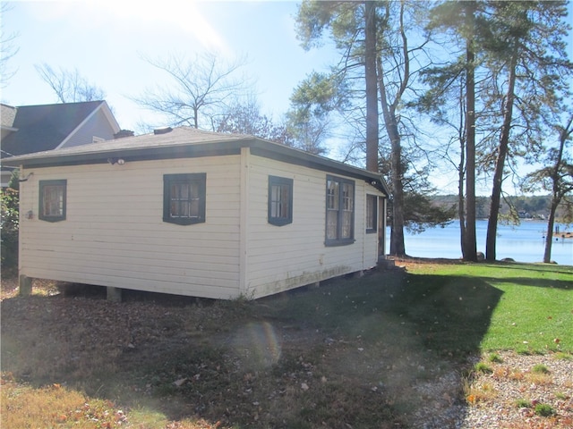 view of side of home featuring a water view and a lawn