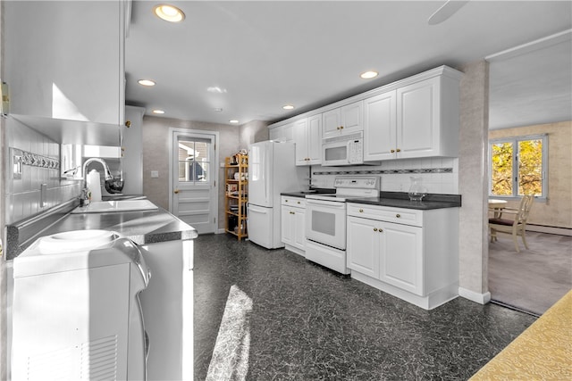 kitchen with white cabinets, decorative backsplash, white appliances, and sink