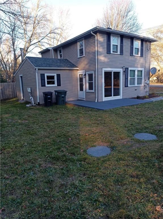 rear view of property with a yard and a patio