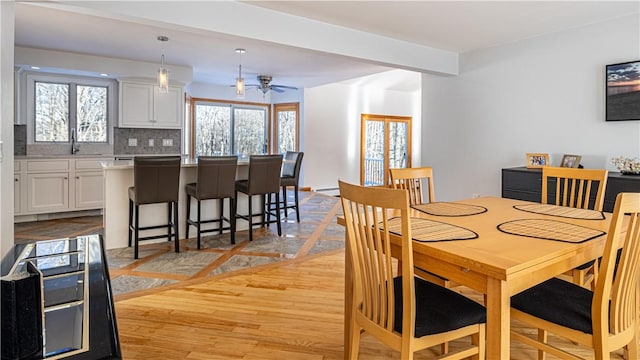 dining area with beamed ceiling, ceiling fan, light hardwood / wood-style floors, and sink