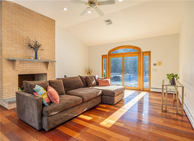 living room featuring ceiling fan, a fireplace, wood-type flooring, and vaulted ceiling