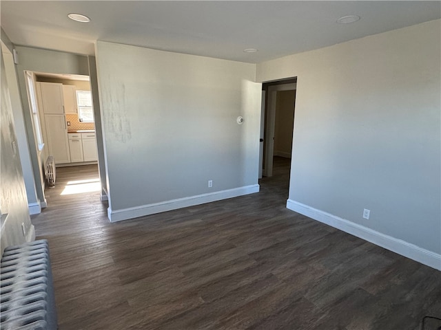 unfurnished room with radiator and dark hardwood / wood-style floors