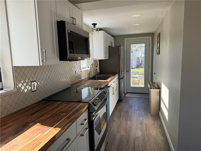 kitchen with white cabinetry, sink, appliances with stainless steel finishes, wooden counters, and dark wood-type flooring