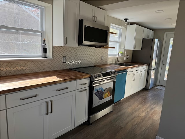 kitchen featuring stainless steel appliances, white cabinets, sink, butcher block countertops, and dark hardwood / wood-style floors