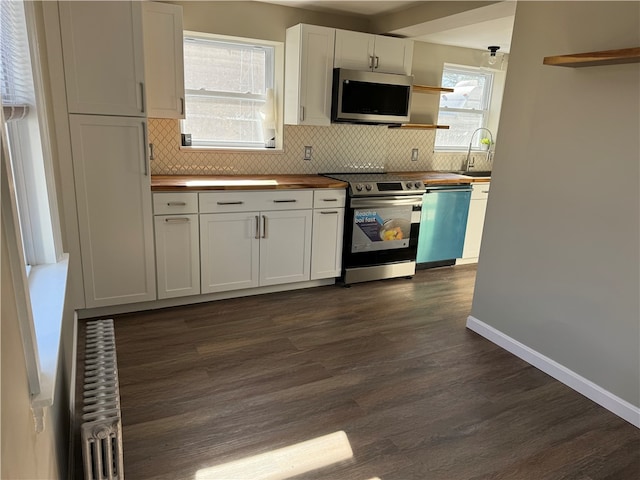 kitchen with white cabinets, plenty of natural light, dark wood-type flooring, and appliances with stainless steel finishes