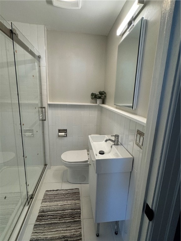 bathroom with toilet, tile patterned floors, tile walls, an enclosed shower, and vanity