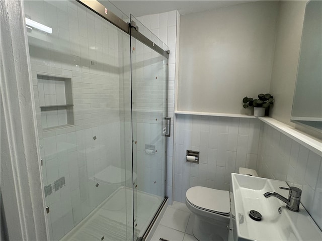 bathroom featuring tile walls, walk in shower, sink, tile patterned flooring, and toilet