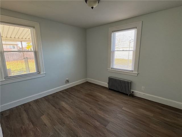 unfurnished room with radiator and dark hardwood / wood-style flooring