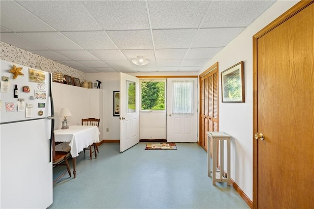 doorway to outside with a paneled ceiling