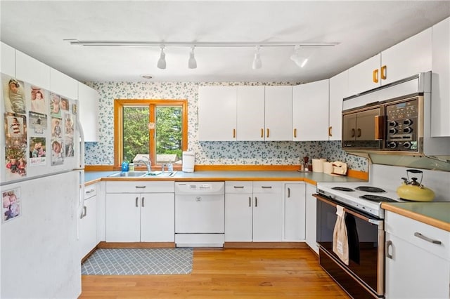 kitchen featuring white cabinetry, rail lighting, white appliances, and light wood-type flooring