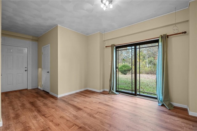 spare room featuring light hardwood / wood-style floors and crown molding