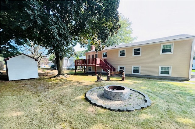 view of yard featuring a fire pit, a storage shed, and a deck