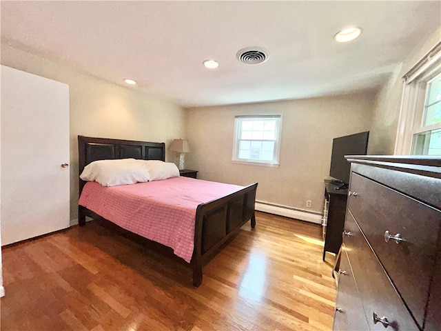 bedroom featuring hardwood / wood-style floors and a baseboard radiator