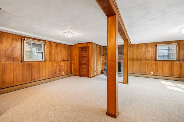 basement with wood walls, light colored carpet, and baseboard heating