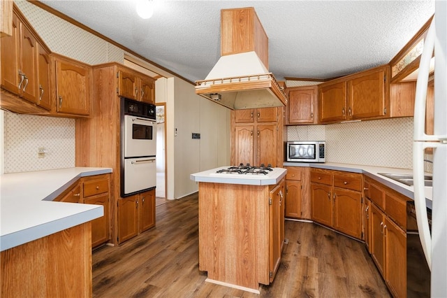 kitchen with dark hardwood / wood-style floors, a kitchen island, white appliances, and a textured ceiling