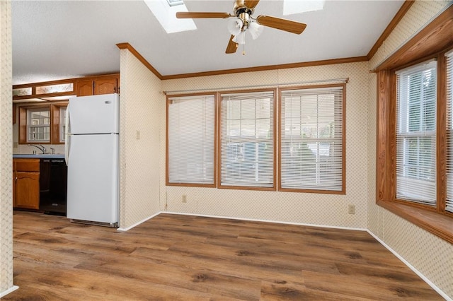 interior space with a wealth of natural light, ornamental molding, and hardwood / wood-style flooring