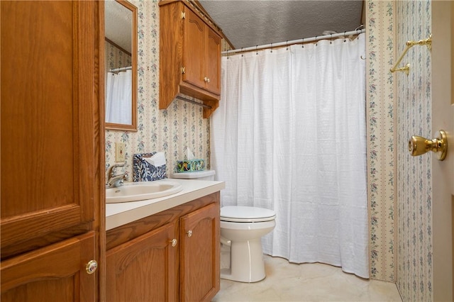 bathroom featuring vanity, toilet, and a textured ceiling