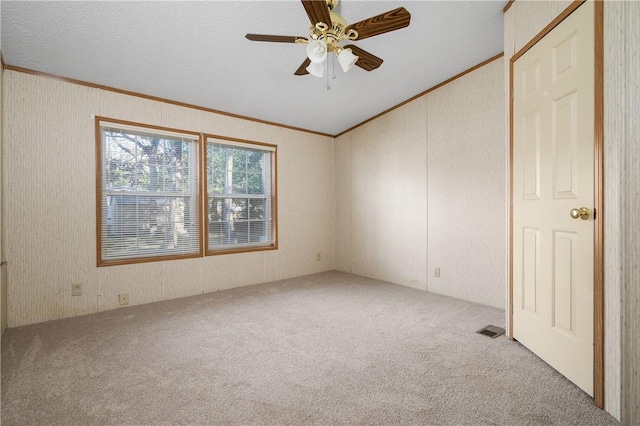 spare room featuring ceiling fan, light colored carpet, a textured ceiling, and ornamental molding