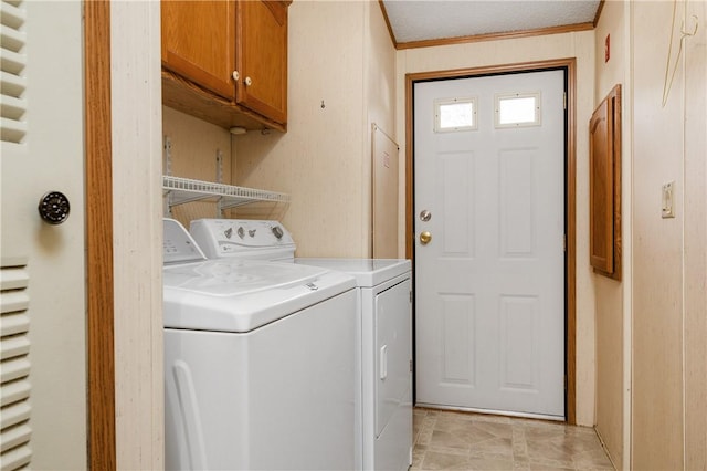 laundry room featuring cabinets, a textured ceiling, washer and clothes dryer, and crown molding