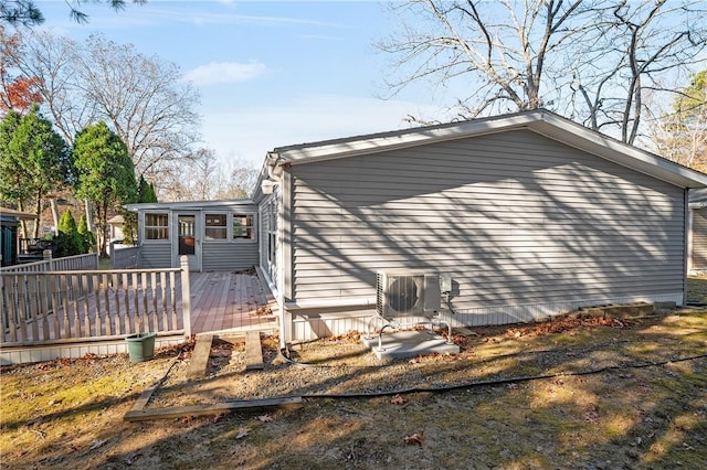 view of side of property with ac unit and a deck