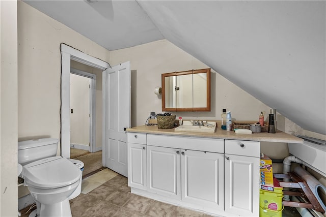 bathroom featuring vanity, lofted ceiling, and toilet