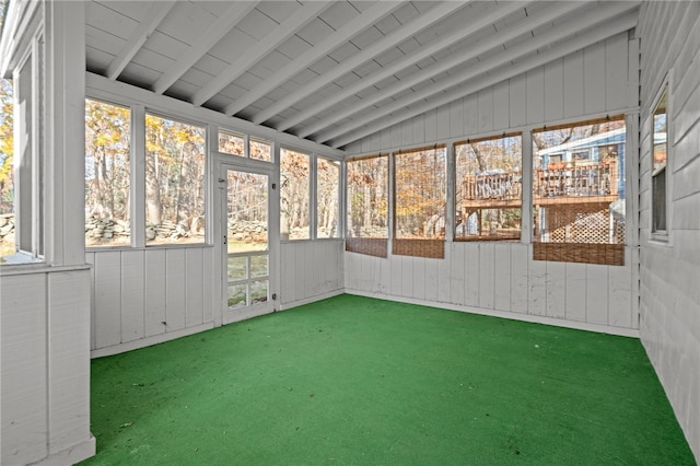 unfurnished sunroom featuring vaulted ceiling with beams