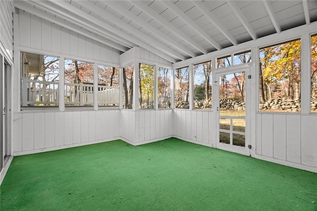 unfurnished sunroom featuring vaulted ceiling with beams