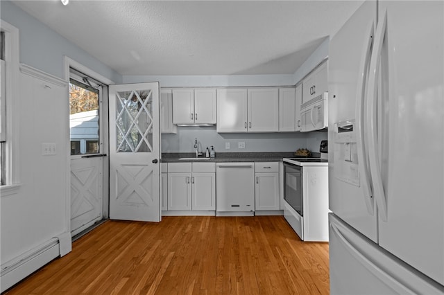 kitchen featuring white cabinetry, sink, a baseboard heating unit, white appliances, and light wood-type flooring