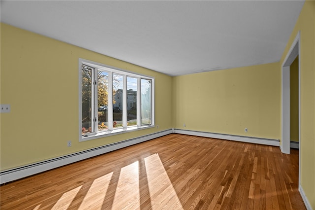 spare room with light wood-type flooring and a baseboard heating unit