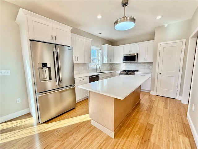 kitchen featuring white cabinetry, premium appliances, hanging light fixtures, and a center island