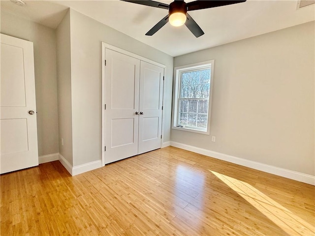 unfurnished bedroom with a closet, ceiling fan, and light wood-type flooring